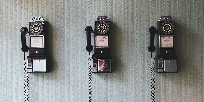 Three vintage telephones on a wall