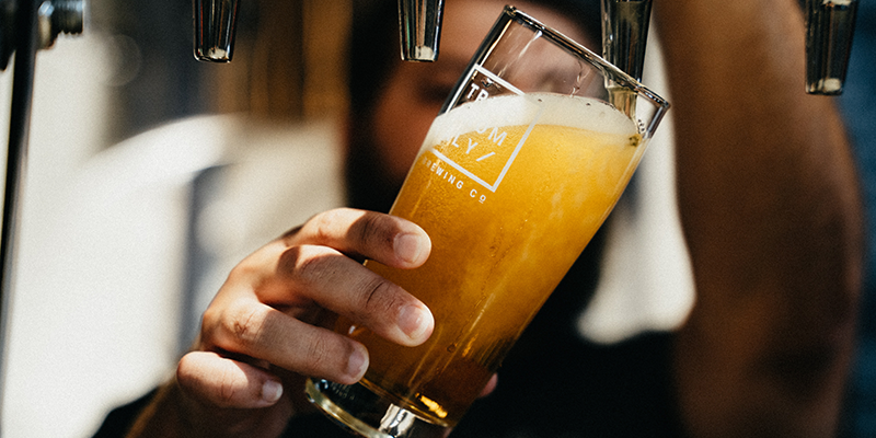 A server filling a beer glass with beer