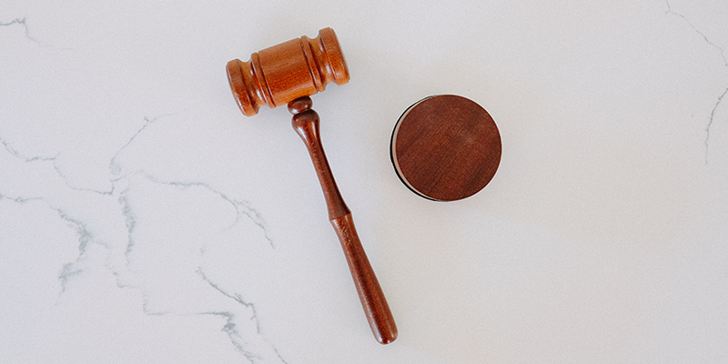 A wooden gavel on a white marble backdrop